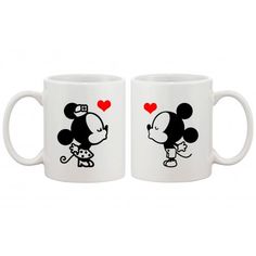 two white coffee mugs with mickey and minnie mouse on the front, one is holding a