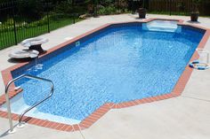 an empty swimming pool surrounded by a black fence