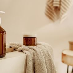 a bottle of lotion sitting on top of a counter next to a towel