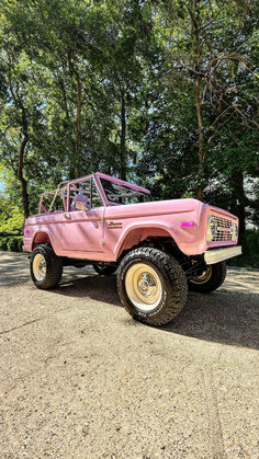 A bold pink vintage Ford Bronco equipped with a Kincer Chassis parked on a tree-lined street, showcasing its unique color and classic beauty. Bronco Golf Cart, Early Bronco, Ford Trucks F150, Pink Jeep, Sport Truck