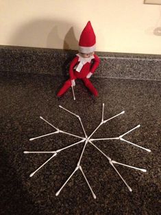 an elf sitting on top of a counter next to toothpicks