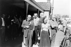 an old black and white photo of people standing in front of a building