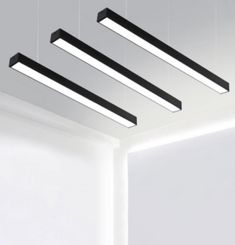 three rectangular lights are suspended from the ceiling in an empty room with white walls and flooring