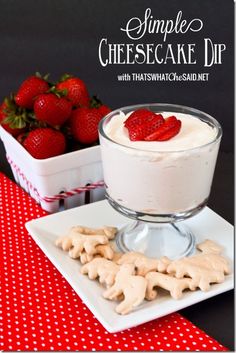 a dessert dish with strawberries and cream in the middle on a red tablecloth