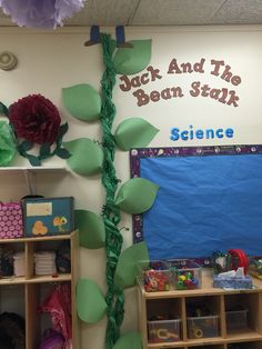 a classroom wall decorated with paper flowers and bookshelves for science fair decorations in front of a sign that says jack and the bean stok