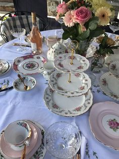 the table is set with dishes, cups and saucers for tea or desserts