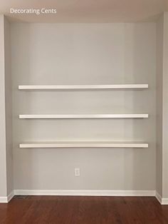 an empty room with white shelving in it and hard wood flooring on the other side