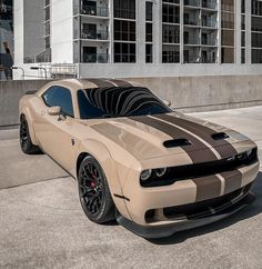 a tan and black sports car parked in front of a building