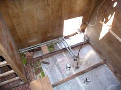 an unfinished bathroom with exposed plumbing and wood walls