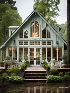 a house that is surrounded by trees and water with stairs leading up to the front door