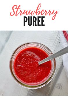 a jar filled with strawberry puree on top of a white table