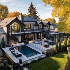 an aerial view of a house with a swimming pool in the front yard and landscaping around it