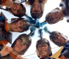 a group of people wearing helmets standing in a circle