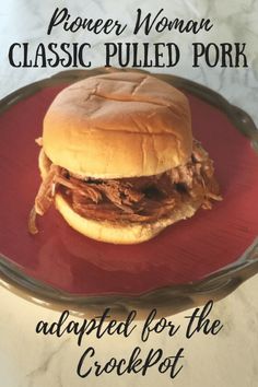 a pulled pork sandwich on a red plate with the words proper woman classic pulled pork adapted for the crockpot