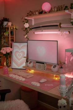 two computer monitors sitting on top of a desk next to pink flowers and other decorations