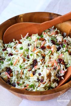 a wooden bowl filled with coleslaw and cranberry pecan slaw