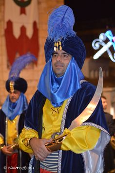 a man dressed in blue and yellow holding a knife