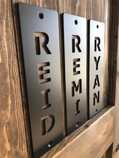 three metal name plaques mounted to a wooden door with the words riemen ryan on them