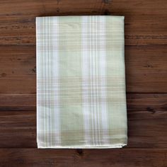 a white and green plaid dish towel sitting on top of a wooden table