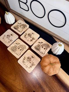 the wooden coasters have pictures of dogs on them and pumpkins next to them