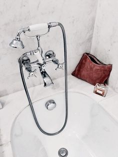 a white sink with a faucet and soap dispenser