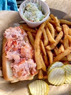 there is a sandwich and some fries on the plate with coleslaw in it