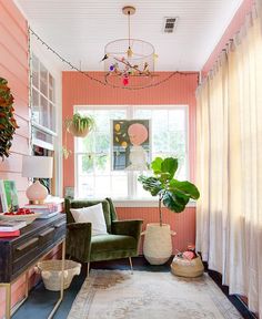 a living room with pink walls and rugs on the floor in front of a window