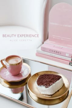 a plate with a piece of cake on it next to a cup and saucer