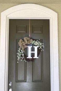 a front door with a wreath and letter h on it