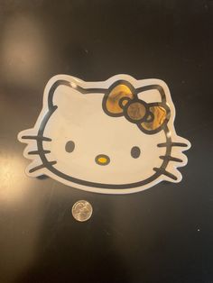 a hello kitty sticker with a gold bow on it's head is shown