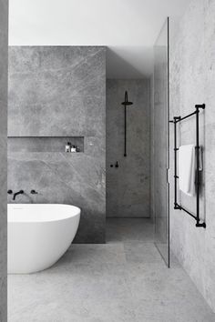 a white bath tub sitting in a bathroom next to a walk - in shower stall