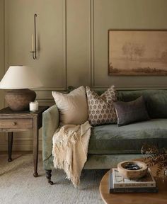 a living room filled with furniture and pillows on top of a couch next to a table