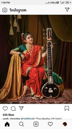 a woman sitting on top of a chair holding a guitar