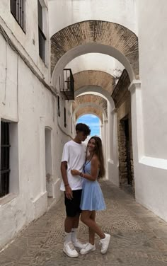 a man and woman standing in an alley way