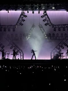 the silhouettes of people on stage during a concert