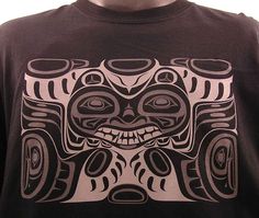 a man wearing a t - shirt with an image of a totem on it