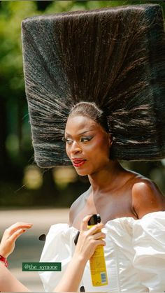 a woman is holding her hair in the air and looking at another woman's face