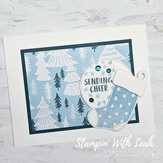 a christmas card with a stocking and snowflakes on it, sitting on top of a table