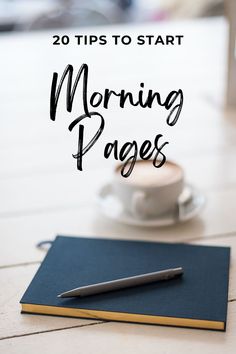 a notebook and pen sitting on top of a table next to a cup of coffee