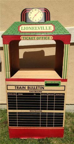 an old fashioned train ticket office sitting in the grass