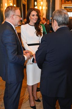 two men and a woman in business attire talking to each other