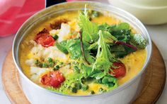 a white bowl filled with food on top of a wooden plate