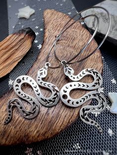 "Hypoallergenic stainless steel moon phase snake hoops are fun wild and witchy!  These snake hoops are latch back style stainless steel hypoallergenic. Snakes are laser cut designed with beautiful moon phases and vines 🌿. Super lightweight statement hoops. Medium sized  LENGTH: 2.5\" HOOPS: 30CM JUST OVER 1\" METAL: STAINLESS STEEL  SILVER COLORED" Snake Jewellery, Earrings Snake, Sparkly Necklace, Snake Jewelry, Snake Earrings, Beautiful Moon, Lasercut Design, Jewelry Earrings Hoops, Moon Phases