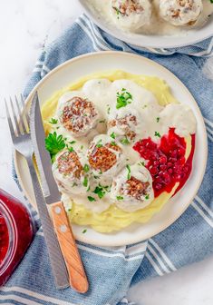 a white plate topped with meatballs covered in gravy and cranberry sauce