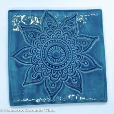 a blue tile with a flower design on it