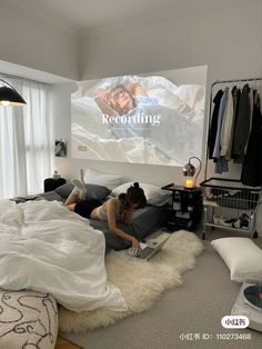 a woman is laying on her bed in front of a projector screen that reads recording