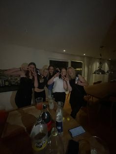 a group of women standing next to each other in front of a table with drinks