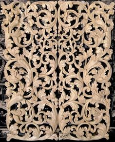 an intricately carved wooden panel with vines and leaves on it's sides, in white