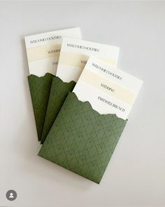 three green envelopes sitting on top of each other in front of a white background