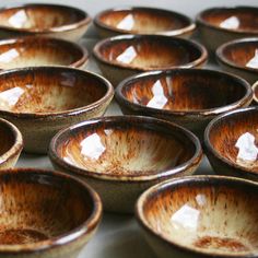 many brown and white bowls sitting on top of a table